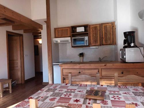une cuisine avec une table et un comptoir dans l'établissement Appartement 6 personnes avec Wifi et magnifique vue montagne - FR-1-508B-7, à Aussois