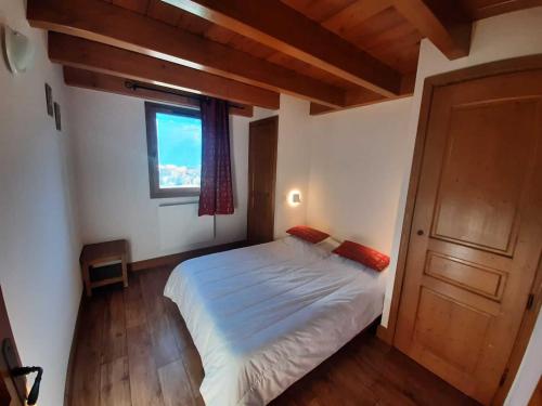 une chambre avec un grand lit avec une fenêtre dans l'établissement Appartement 6 personnes avec Wifi et magnifique vue montagne - FR-1-508B-7, à Aussois