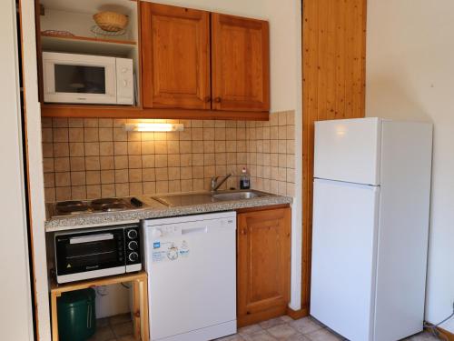 une cuisine avec un réfrigérateur blanc et un évier dans l'établissement Appartement chaleureux à Aussois, 6 pers, proche navettes - FR-1-508B-10, à Aussois