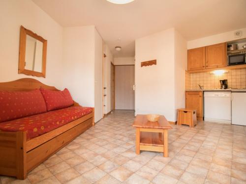 un salon avec un canapé rouge et une cuisine dans l'établissement Appartement calme proche navettes gratuites - FR-1-508B-9, à Aussois