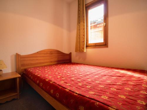 - une chambre avec un lit rouge et une fenêtre dans l'établissement Appartement calme proche navettes gratuites - FR-1-508B-9, à Aussois