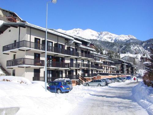 un parking couvert de neige en face d'un bâtiment dans l'établissement Appartement 4 pers avec terrasse et vue montagne à Aussois - FR-1-508B-19, à Aussois
