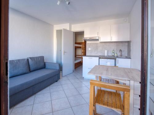 un salon avec un canapé bleu et une cuisine dans l'établissement Studio rénové pour 4 pers avec balcon, animaux admis - Morillon - FR-1-642-103, à Morillon