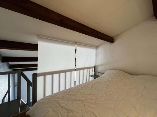 - une chambre avec un lit et une fenêtre avec un store dans l'établissement Appt climatisé avec terrasse, parking privé, Gruissan - FR-1-229-896, à Gruissan