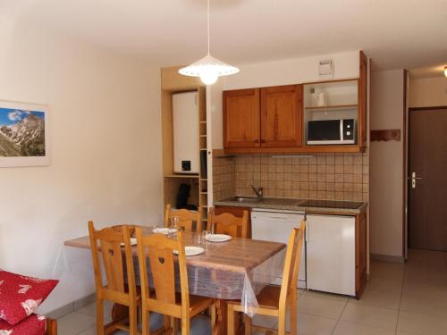 une cuisine et une salle à manger avec une table et des chaises dans l'établissement Appartement cosy avec terrasse et parking sous-terrain à Aussois - FR-1-508B-27, à Aussois