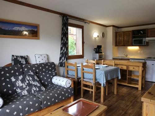 un salon avec un canapé et une table et une cuisine dans l'établissement Appartement spacieux pour 6 avec WIFI à Aussois - FR-1-508B-35, à Aussois