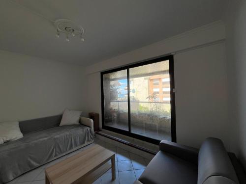 un salon avec un canapé et une grande fenêtre dans l'établissement Studio cosy à Arcachon - Centre ville, plage à pied, parking privé - FR-1-319-604, à Arcachon