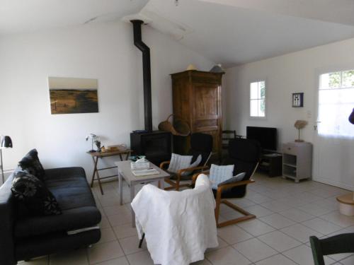 un salon avec un canapé et des chaises dans l'établissement Maison confortable à Barbâtre pour 4 personnes, proche plage - FR-1-823-150, à Barbâtre