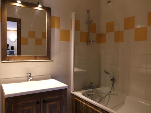 une salle de bain avec un lavabo, une baignoire et un miroir dans l'établissement Appartement spacieux 6 personnes avec vue, WiFi gratuit - FR-1-508B-30, à Aussois