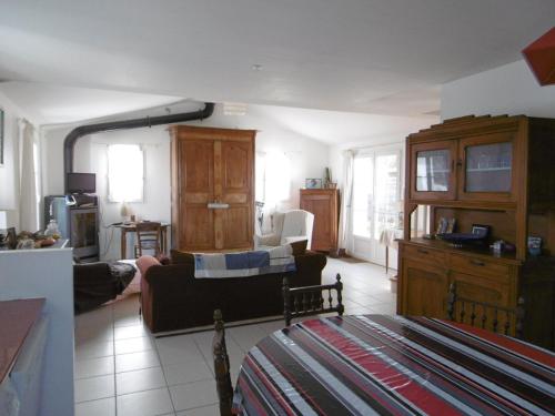 un salon avec un canapé et une cuisine dans l'établissement Maison mitoyenne confort à Barbâtre proche plage, jusqu'à 10 pers - FR-1-823-151, à Barbâtre