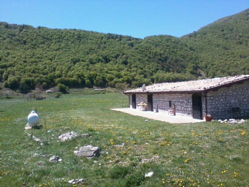 a stone building in a field next to a mountain at Chalet Vista Lago in San Gregorio
