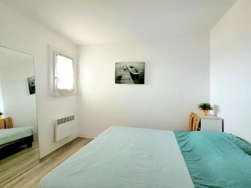 une chambre blanche avec un lit et une fenêtre dans l'établissement T2 à Canet-en-Roussillon - 4 personnes, parking, vue mer - FR-1-794-162, à Canet