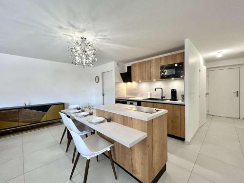 une cuisine avec une table et des chaises dans une pièce dans l'établissement Grand appartement 3 pièces cabine, terrasse, garage - Briançon - FR-1-330C-151, à Briançon