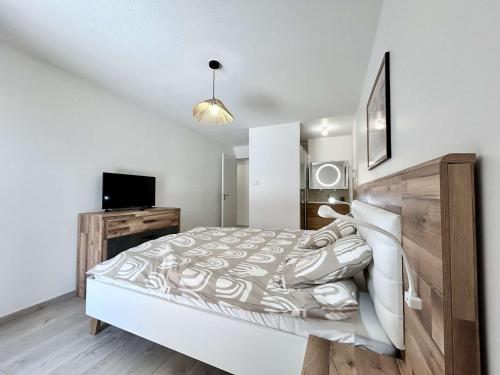 une chambre avec un grand lit et une télévision dans l'établissement Grand appartement 3 pièces cabine, terrasse, garage - Briançon - FR-1-330C-151, à Briançon