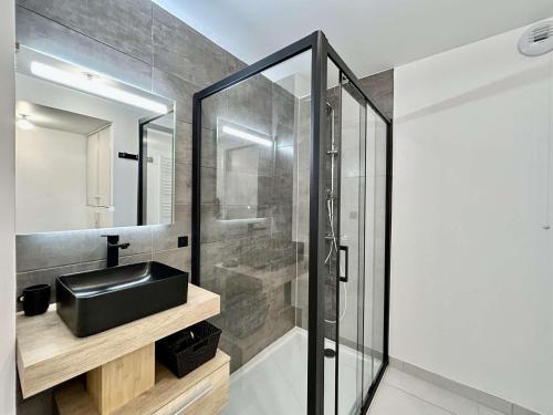 La salle de bains est pourvue d'un lavabo noir et d'une douche. dans l'établissement Grand appartement 3 pièces cabine, terrasse, garage - Briançon - FR-1-330C-151, à Briançon