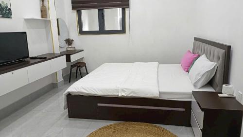a bedroom with a bed with a desk and a television at Nguyên căn Homestay -Nhà Mẹ Khang 1 in Cu Chi