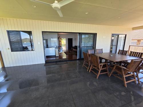 a dining room with a wooden table and chairs at Russ Vegas in Russell Island