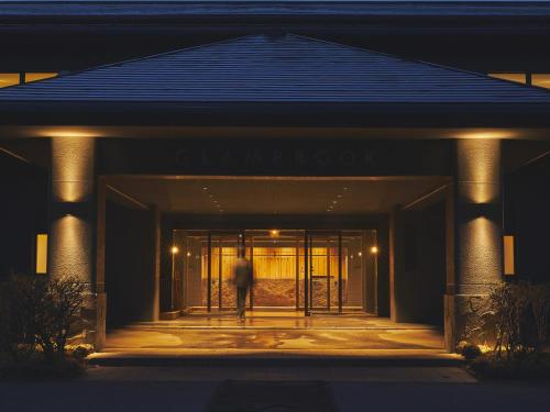 a person standing in front of a building at night at Glamprook Iizuna in Iizuna