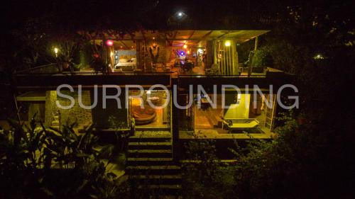 a lit up sign in front of a house at night at Rumah Lereng Bandung in Bandung