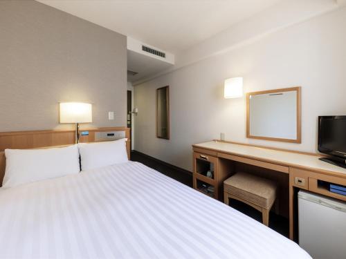 a hotel room with a bed and a desk at Nishitetsu Inn Tenjin in Fukuoka
