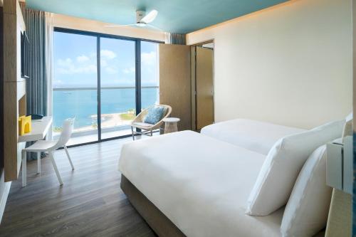 En eller flere senge i et værelse på OZO North Pattaya