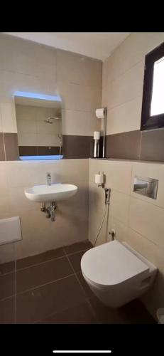 ein Badezimmer mit Toilette und Waschbecken in der Unterkunft American Home in M'bour