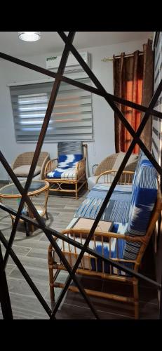 ein Zimmer mit Stühlen, einem Bett und einem Tisch in der Unterkunft American Home in M'bour