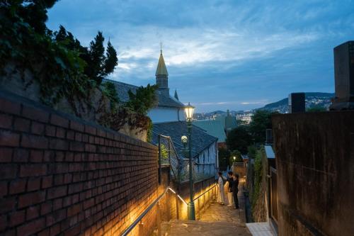 a group of people walking down a street at night at Setre Glover's House Nagasaki in Nagasaki