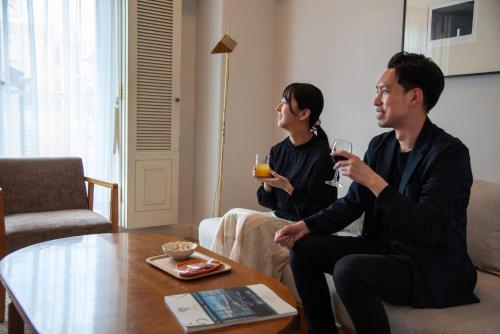 two people sitting in a living room drinking wine at Setre Glover's House Nagasaki in Nagasaki