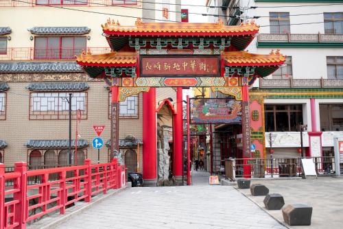 a red gate with a sign in front of a building at Setre Glover's House Nagasaki in Nagasaki
