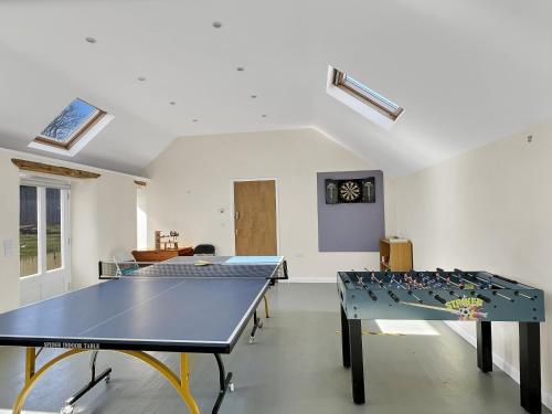 a room with two ping pong tables in it at The Barn at Rainsbury House Upton in Upton