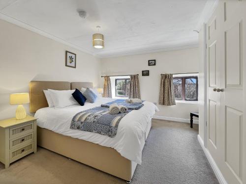 a bedroom with a large bed and a window at The Barn at Rainsbury House Upton in Upton
