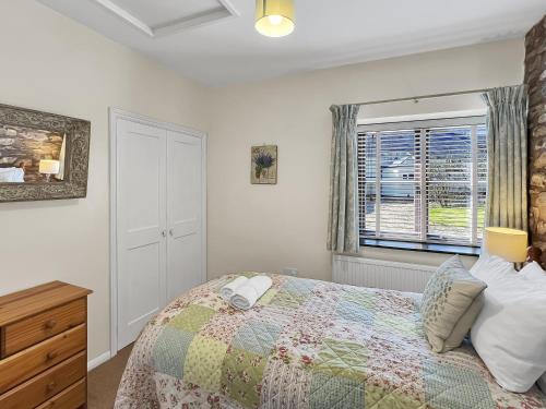 a bedroom with a bed and a window at The Barn at Rainsbury House Upton in Upton