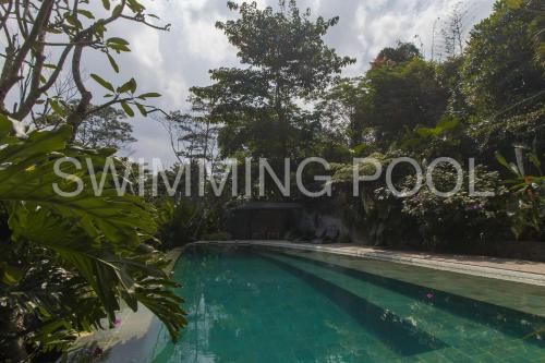 a swimming pool in a garden with trees at Rumah Lereng Bandung in Bandung