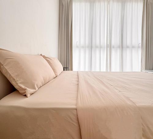 a white bed with a pillow and a window at Georgetown Seaview & Cityview Childroom Infinity pool with Carpark in Jelutong