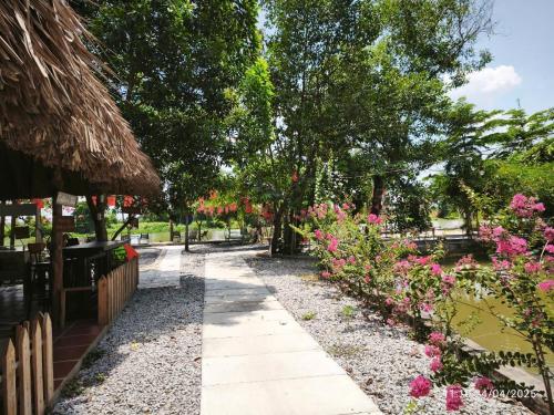 a garden with pink flowers and a pathway at Cắm trại trong ngày view sông - Homestay Mẹ Khang 2 in Cu Chi