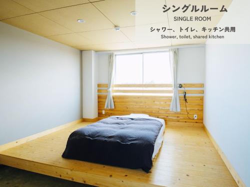 a bedroom with a bed on a wooden floor at HIKE in Tamana