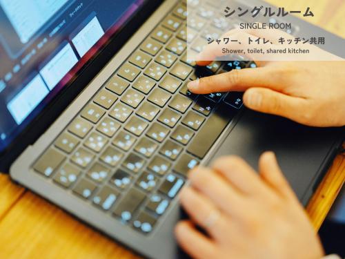 a person is typing on a laptop computer at HIKE in Tamana