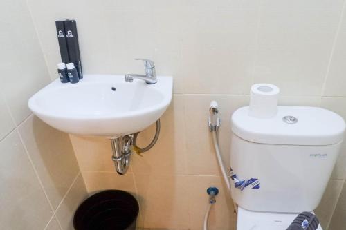 a bathroom with a sink and a toilet at Vibrant Modern Studio Room at Bale Hinggil Apartment By Travelio in Medokanayu