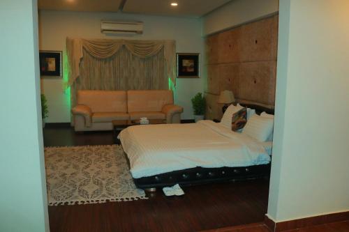 a bedroom with a bed and a couch at Safari Club 1 in Rawalpindi