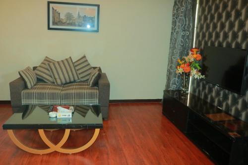 a living room with a couch and a coffee table at Safari Club 1 in Rawalpindi