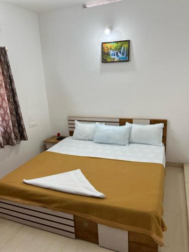 a bedroom with a bed with a blanket on it at kollam Beach Resort in Kollam
