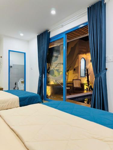 a bedroom with two beds and a large window at MON House 2 in Ấp Sung Xuân