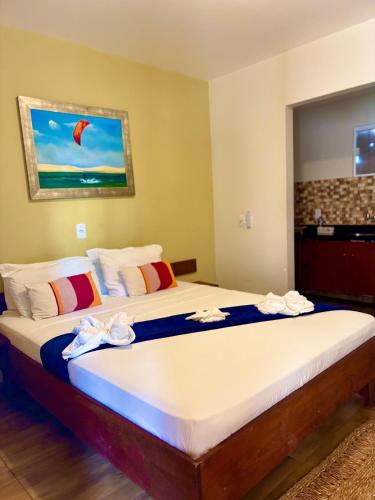 a bedroom with a large bed with towels on it at Morada das Dunas in Atins