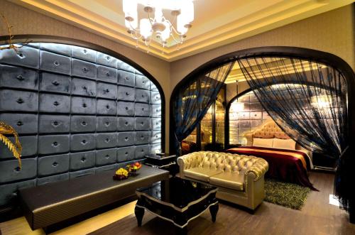 a bedroom with a bed and a couch and a table at Hea Duenn Motel in Taichung