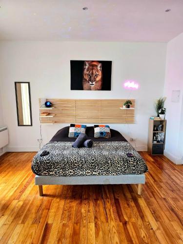 a bedroom with a bed with a lion picture on the wall at Le 2005 Double BALNEO, Lit QUEEN SIZE, soirée romantique in Grenoble