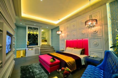 a bedroom with a bed and a couch and a chair at Hea Duenn Motel in Taichung