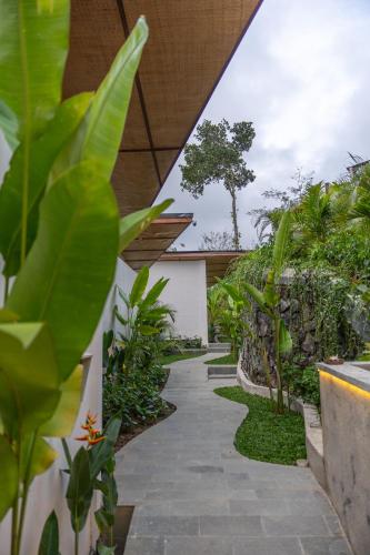 a walkway through a garden with plants at Micaela Bali Ubud Villas in Tegalalang
