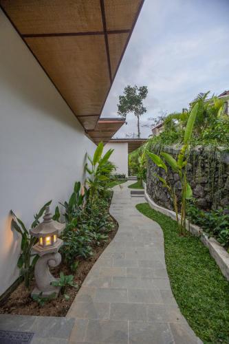 a walkway in a garden with a lantern at Micaela Bali Ubud Villas in Tegalalang