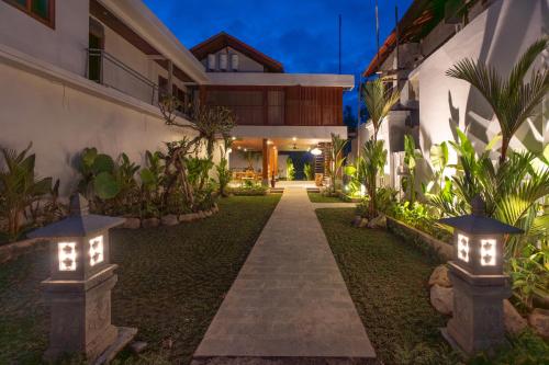 a pathway in front of a building with lights at Micaela Bali Ubud Villas in Tegalalang
